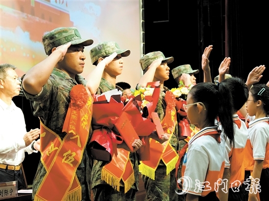 小學(xué)生代表向入伍新兵代表獻上鮮花。