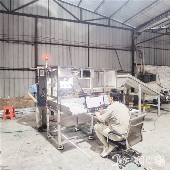 鷹視光電工作人員正在對AI視覺檢測設(shè)備進(jìn)行調(diào)試。