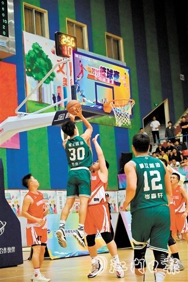 萬(wàn)村籃球賽江門(mén)市級(jí)賽決賽現(xiàn)場(chǎng)，橫江村隊(duì)隊(duì)員迎著防守跳投得分。