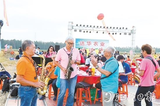 表演人員在稻田里吹響薩克斯風(fēng)，與澳門禮樂鄉(xiāng)親齊慶豐收。