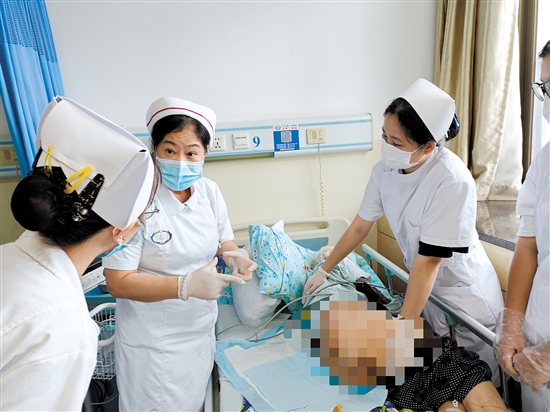 朱敏林（中）與同事對(duì)患者進(jìn)行護(hù)理服務(wù)。