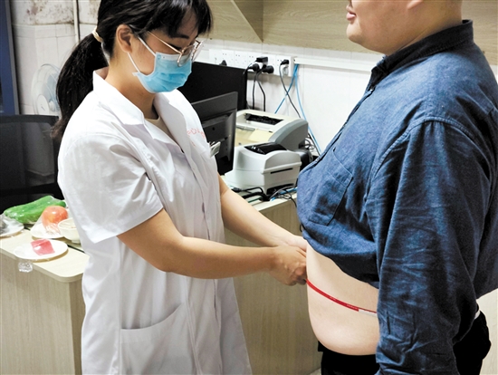 醫(yī)生為記者測(cè)量腰圍。