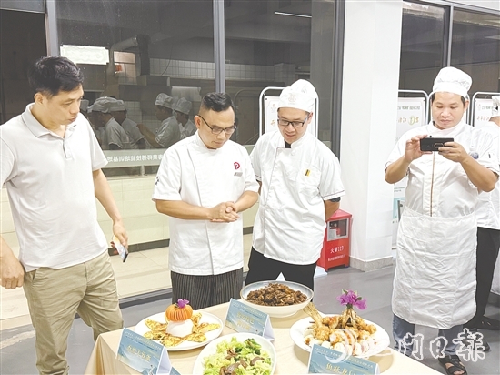 伍立更（左二）對(duì)學(xué)員們的自創(chuàng)菜式一一進(jìn)行點(diǎn)評(píng)和指導(dǎo)。