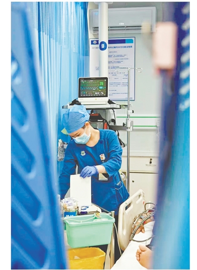 這是一雙爭(zhēng)分奪秒的手。急診搶救室是與時(shí)間賽跑的“生命戰(zhàn)場(chǎng)”，收治的都是急危重癥患者，生死往往就在一瞬間。面對(duì)心梗病人，江門市中心醫(yī)院急診科護(hù)士譚秀娟正專心致志地為患者做心電圖檢查，用專業(yè)與仁心守護(hù)生命之光。