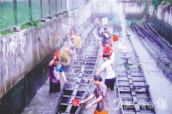 在水口鎮(zhèn)龍東村委會欖沖村，村民們合力將深埋河底的龍舟“喚醒”，為即將到來的端午龍舟賽事做準備。