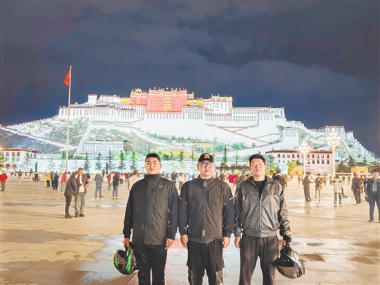 余鴻威（左一）與摩友在拉薩布達拉宮前合影留念。