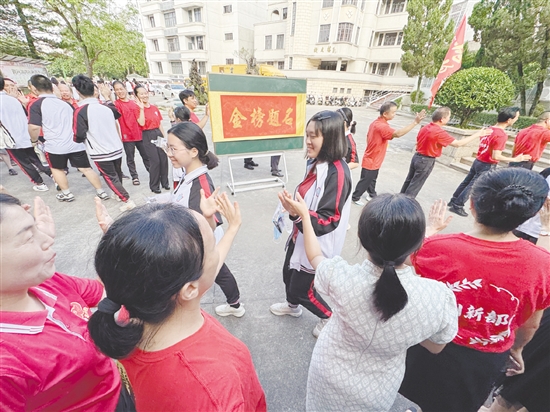 臺(tái)山一中在送考路上設(shè)置了“金榜題名”大字帖，教師身穿紅衣與學(xué)生擊掌，為學(xué)生加油。
