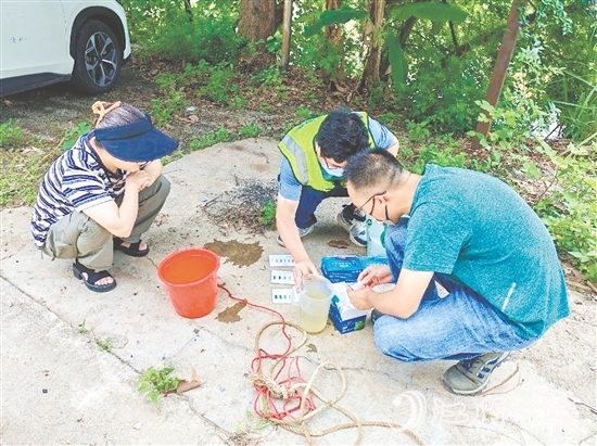 巡河過(guò)程中，工作人員沿河查看并采集水樣進(jìn)行檢測(cè)。