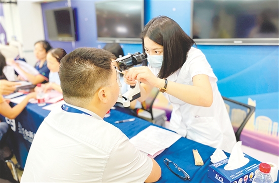 醫(yī)護人員為企業(yè)職工檢查眼睛。