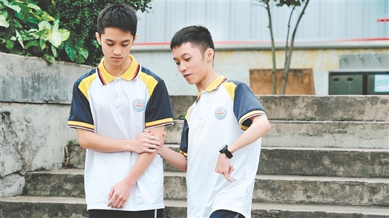 校園里，弟弟（左）和哥哥（右）相互扶持。