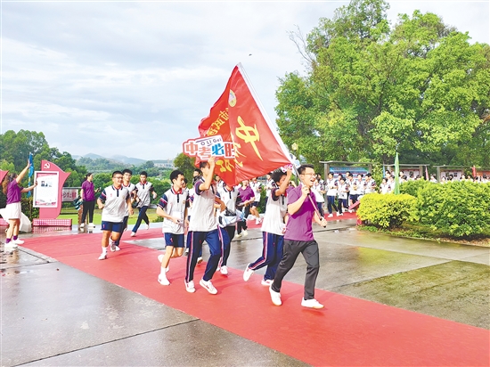 在臺(tái)山市武溪中學(xué)，老師揮舞著“中考加油”的紅旗為考生加油助威。