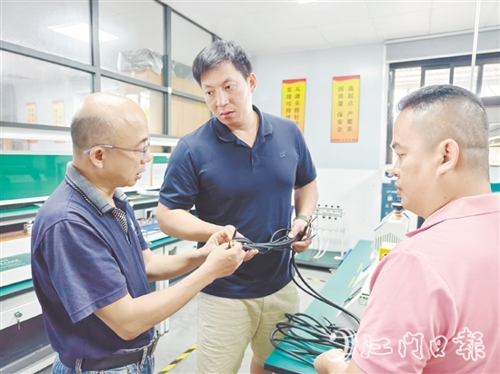 盧慶忠（中）與技術(shù)人員交流產(chǎn)品質(zhì)量問(wèn)題。