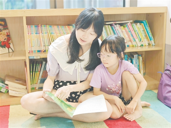 在龍溪湖閱讀中心，一位家長正陪伴孩子讀繪本。