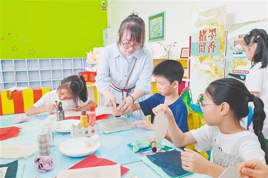 在導(dǎo)師的指導(dǎo)下，孩子們紛紛拿起紙張，在拓板上謹(jǐn)慎操作。