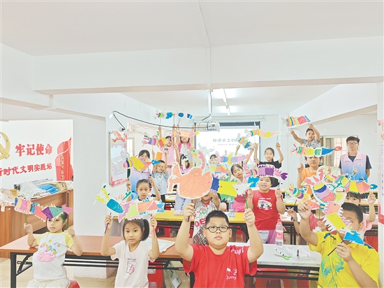 孩子們手持自制荷塘紗龍一起合照，課堂變民俗小舞臺。