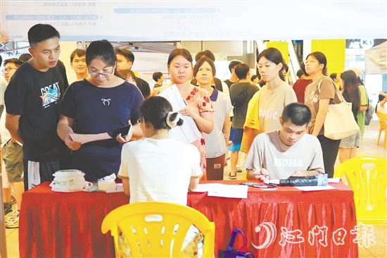 活動現(xiàn)場，求職者手持簡歷與企業(yè)招聘人員進行交流。