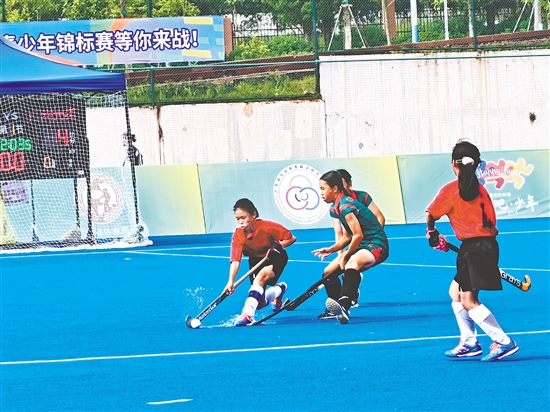 共和鎮(zhèn)中心小學(xué)女子曲棍球隊隊員（紅色隊服）在比賽中頑強拼搏。