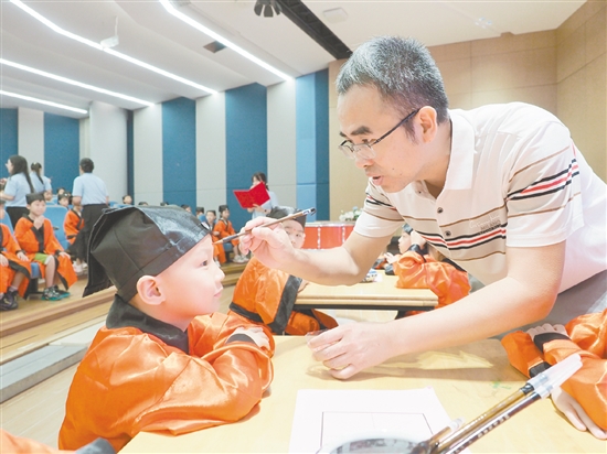 在朱砂啟智環(huán)節(jié)，教師用毛筆在新生的額頭點上紅痣。