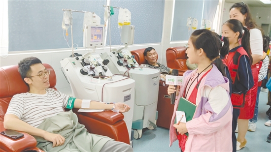 小記者采訪正在獻(xiàn)血的志愿者。