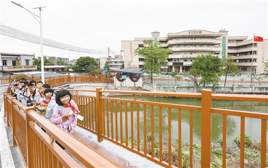 雙橋小學(xué)的學(xué)生放學(xué)后在新修建的步道上結(jié)伴而行，身旁的車流被欄桿有效隔離，構(gòu)筑起校園交通的安全防線。