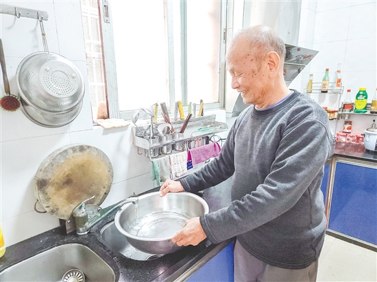 榕樹村村民麥成建在廚房用干凈的自來水清洗餐具。