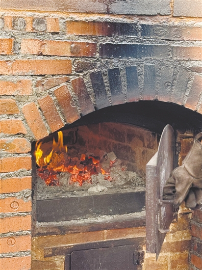 荔枝柴要燒兩個多小時，窯爐溫度到350℃以上才能烤面包。