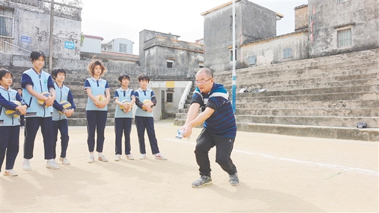 伍超明給孩子們演示墊球。
