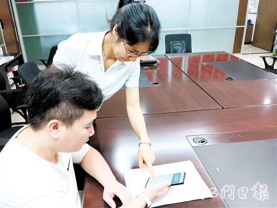 工作人員在指導(dǎo)市民線上交存住宅專項維修資金。陸沿任