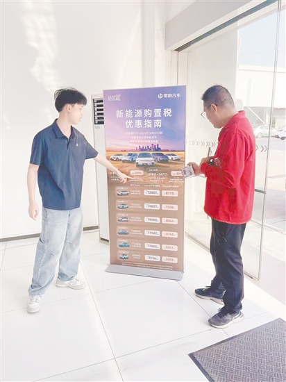 銷售人員向市民介紹優(yōu)惠政策。